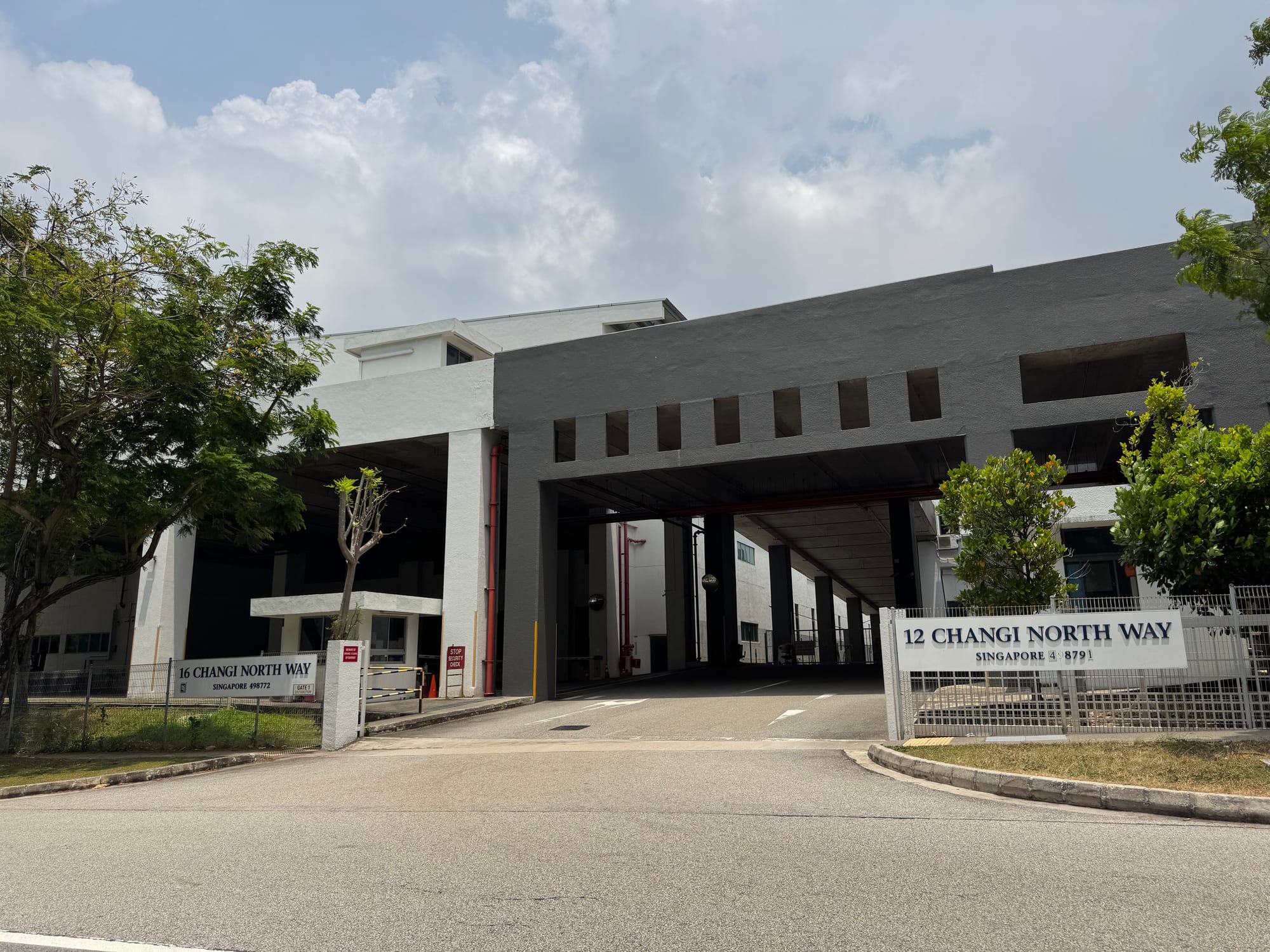 Entrance gate signage for 12 and 16 Changi North Way with the covered driveway between blocks