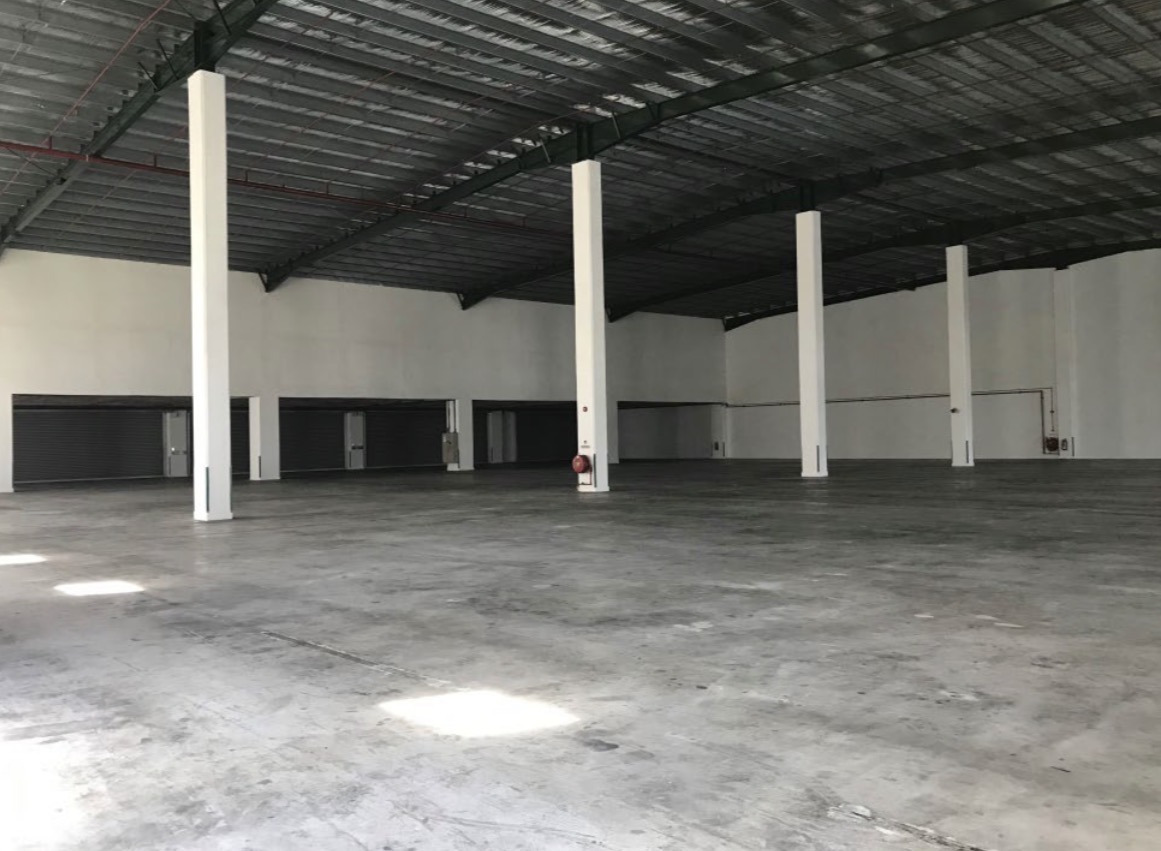 Warehouse bay with steel roof trusses and roller shutter loading doors